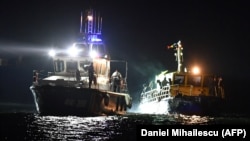 A border police ship pulls a vessel transporting migrants the port of Midia on the Black Sea coast on September 13.