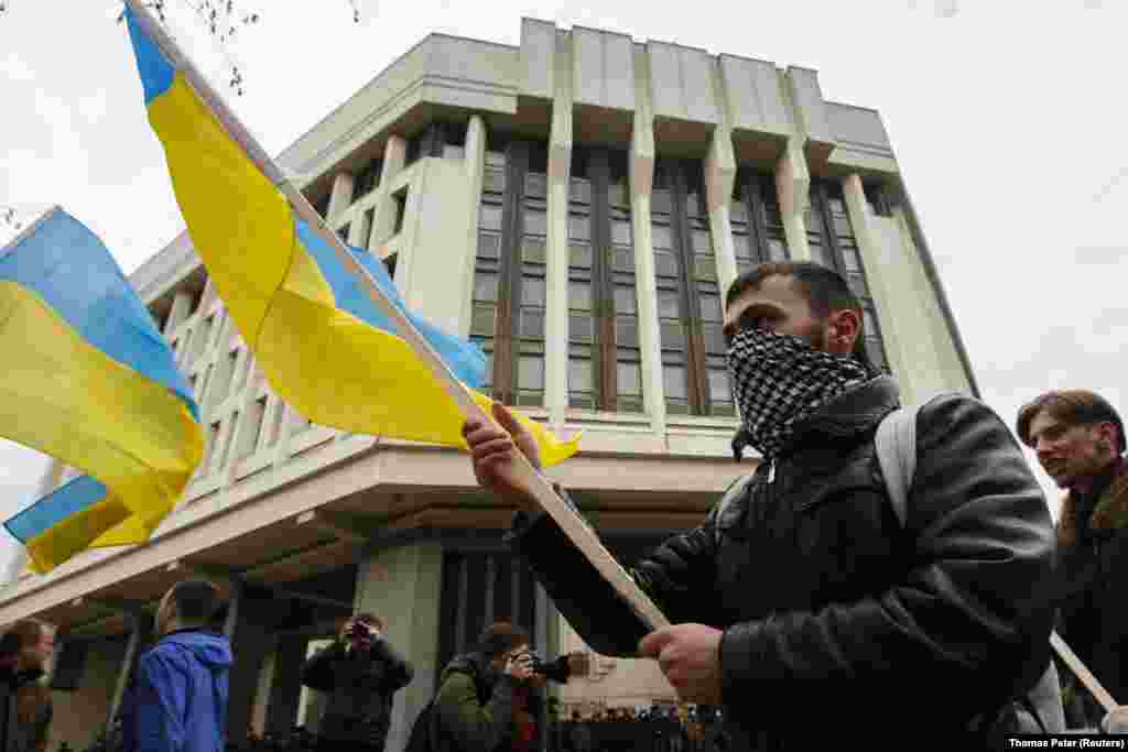Проукраїнські протестувальники перед будівлею парламенту Криму в Сімферополі, 8 березня 2014 року. Після того, як проросійські сили перервали трансляцію українських новинних передач та розпочали трансляцію російських державних телеканалів, кілька груп іноземних журналістів, які працювали в Криму, постраждали від нападів, а двоє українських журналістів було викрадено