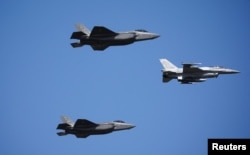 Амэрыканскія зьнішчальнікі F-35 і польскі зьнішчальнік амэрыканскай вытворчасьці F-16 на парадзе ў Польшчы, 15 жніўня 2023