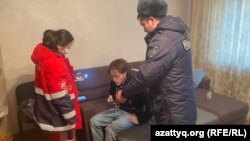 Журналист Данияр Молдабеков в окружении работницы бригады скорой помощи и полицейского, прибывших к нему после его сообщения о нападении на него. 22 февраля 2023 года
