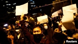 Učesnici protesta u Kini zbog strogih kovid ograničenja drže prazne bele listove papira, Peking 27. novembar 2022.
