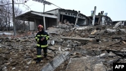 Spasilac hoda među ruševinama uništene zgrade nakon ruskih napada u Harkivu, Ukrajina, 16. decembra 2022.