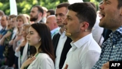 Ukrainian President Volodymyr Zelensky (second right) and participants sing the national anthem during his Servant of the People party's conference before the recent parliamentary elections. Many of the candidates chosen at this event will now be entering parliament for the first time. 