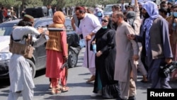 تصویر آرشیف: یکی از افراد طالبان میلهٔ تفنگ خود را به جانب یکی از زنان معترض در کابل نشانه گرفته است