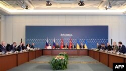 Members of Ukrainian (R), Russian (L) and Turkish (C) delegations attend peace talks at the Ciragan Palace in Istanbul, June 2, 2025.