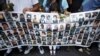Devojčica drži poster sa fotografijama žrtava Srebrenice tokom ispraćaja kolone sa posmrtnim ostacima 409 žrtava genocida, Sarajevo, 9. jul 2013.