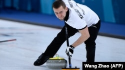 Russia's Aleksandr Krushelnitsky brushes the ice during the curling mixed doubles during the Winter Olympic Games on February 8.