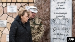 German Chancellor Angela Merkel (left) and Bundeswehr Commandant Erich Pfeffer in front of the memorial to fallen soldiers at the German base in Mazar-e Sharif on March 12.