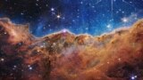 «Касьмічныя скалы» туманнасьці Кіля. Здымак зроблены з дапамогай касьмічнага тэлескопа Джэймса Ўэбба. Воблачная туманнасьць унізе аддзяляецца хвалістай лініяй ад верхняй, больш празрыстай часткі. На фота — мноства зорак рознага памеру. Здымак апублікаваны NASA 12 ліпеня 2022 году