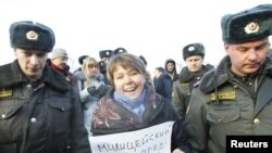 Interior Ministry officers detain environmental activist Yevgenia Chirikova during a protest against the construction of a motorway through Khimki Forest.