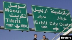 Workers add Turkoman language translations to traffic signs in multiethnic Kirkuk.