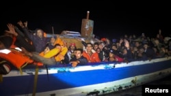 Migrants on board a drifting, overcrowded wooden boat react during a rescue operation by the Spanish NGO Proactiva Open Arms, north of the Libyan city of Sabratha in the central Mediterranean Sea, in March.