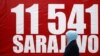 Мусульманка проходит мимо баннера с цифрой 11 541 - число погибших в результате осады Сараево. 6 апреля 2012 года.