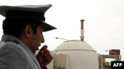 An Iranian security guard stands outside the building housing the reactor of Bushehr nuclear power plant