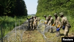 Літоўскія салдаты абгароджваюць мяжу зь Беларусьсю.