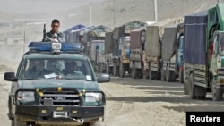 A police vehicle drives past trucks carrying voting materials in the Afghan capital, Kabul, on September 16.