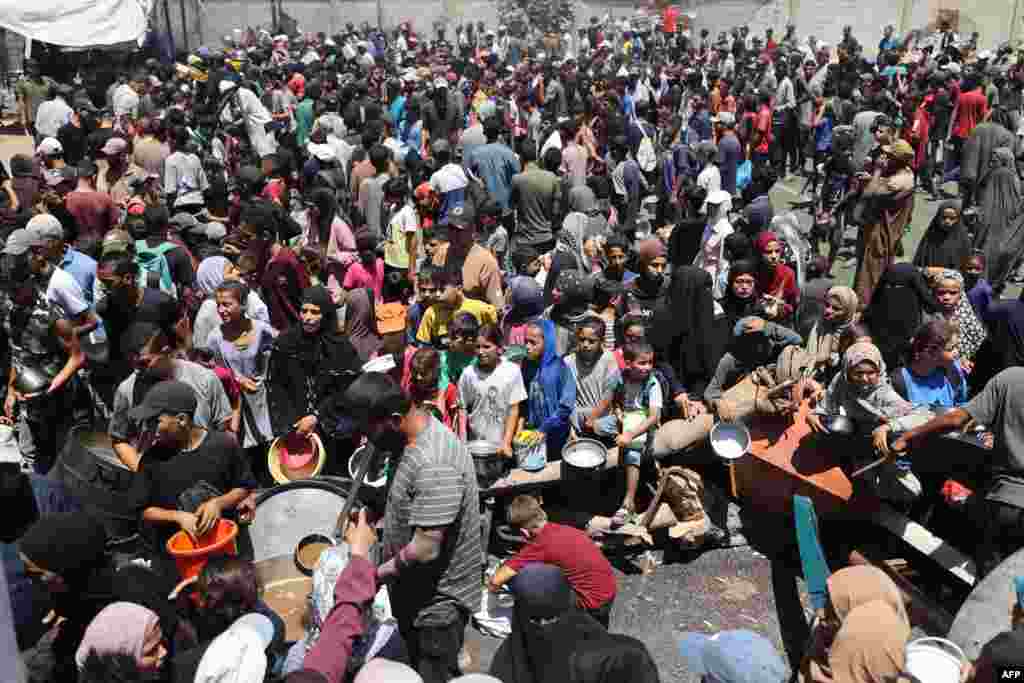 Palestinienii se adună la un punct de distribuție a alimentelor în tabăra de refugiați Nuseirat din centrul Fâșiei Gaza, pe 19 iulie 2025.