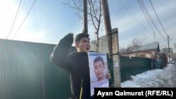 Байболат Кунболатулы с портретом своего брата проводит пикет напротив консульства Китая. Через некоторое время он был задержан полицией. Алматы, 1 февраля 2021 года.