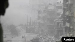 Smoke rises from buildings after what activists said was shelling from government forces in the besieged area of Homs, where the United States called on the government to permit aid to enter.
