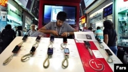 A shopkeeper adjusts mobile-phone handsets at a shopping center in Tehran. (file photo)