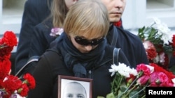 Žena nosi portret bjeloruskog novinara Aleha Byabenina za vrijeme njegove sahrane u Minsku, 06. rujan 2010.