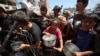 Palestinieni adunați la un centru de distribuire a alimentelor din tabăra de refugiați Nuseirat din centrul Fâșiei Gaza. 19 iulie 2025.