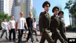 New Belarusian army recruits march behind officers near a recruiting station in Minsk 