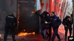 Policajci privode demonstranta na skupu u Sofiji, Bugarska, 22. februara 2025.