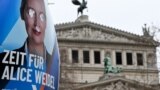 A defaced election campaign poster featuring a portrait of Germany's far-right Alternative for Germany (AfD) party co-leader and main candidate Alice Weidel is pictured in front of the Opera building in Frankfurt am Main, western Germany on February 14, 2