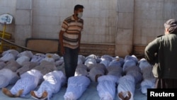Activists inspect the bodies of people they say were killed by nerve gas in the Ghouta region near Damascus on August 21.