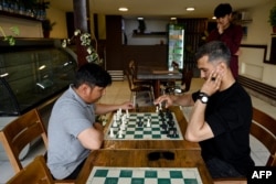 Men play chess at the Cupcake Coffee Shop cafe in Kabul just before the Taliban suspended the sport on May 11, 2025.