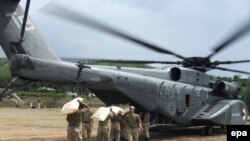 Pakistani soldiers load food supplies for stranded flood victims onto a U.S. Navy helicopter for distribution in August 2010.
