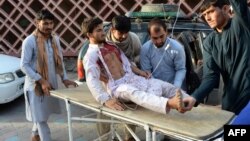 Volunteers carry an injured man on a stretcher to a hospital following the suicide bombing in Nangarhar on June 16.